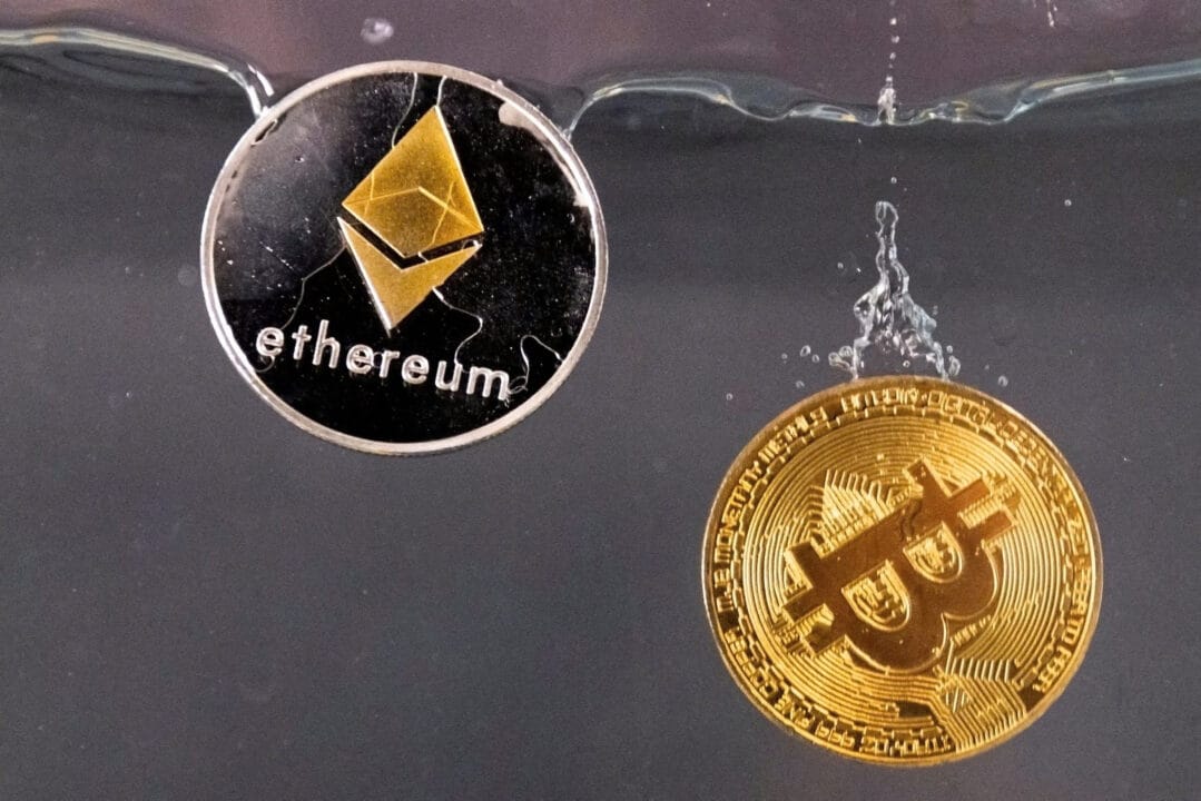Các mã thông báo lưu niệm đại diện cho tiền điện tử Bitcoin và mạng lưới Ethereum, với mã thông báo gốc là ether, rơi xuống nước trong hình minh họa này được chụp vào ngày 17 tháng 5 năm 2022