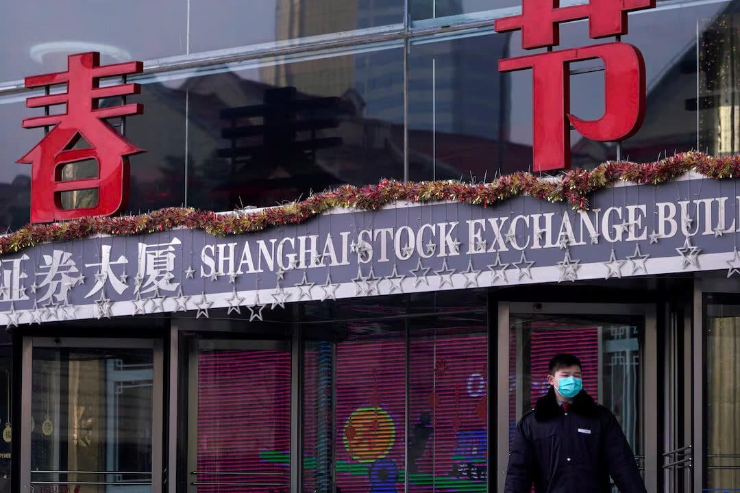 Một nhân viên bảo vệ đứng tại tòa nhà Sàn giao dịch chứng khoán Thượng Hải ở khu tài chính Phố Đông tại Thượng Hải