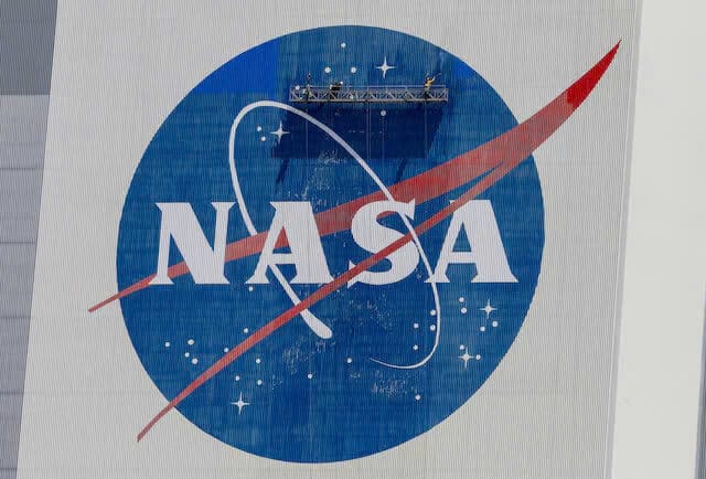 Công nhân rửa sạch logo của NASA trên Tòa nhà lắp ráp phương tiện trước khi SpaceX đưa hai phi hành gia của NASA lên Trạm vũ trụ quốc tế trên tên lửa Falcon 9, tại Trung tâm vũ trụ Kennedy ở Cape Canaveral, Florida, Hoa Kỳ, ngày 19 tháng 5 năm 2020