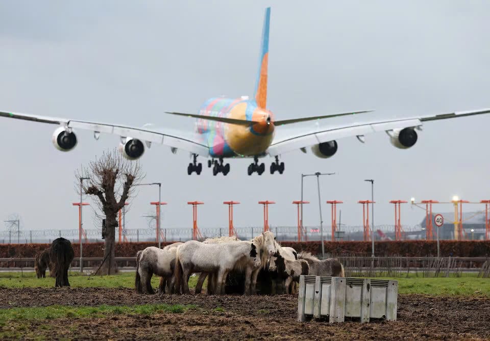 Một chiếc máy bay chở khách của British Airways bay qua biển báo chỉ đường khi đang hạ cánh xuống Sân bay Heathrow ở phía tây London, Anh, ngày 28 tháng 1 năm 2025