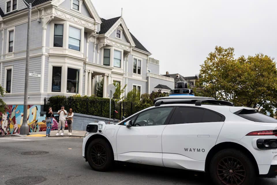 Mọi người chụp ảnh một chiếc taxi không người lái Waymo đi ngang qua San Francisco, California, Hoa Kỳ, ngày 28 tháng 9 năm 2024.